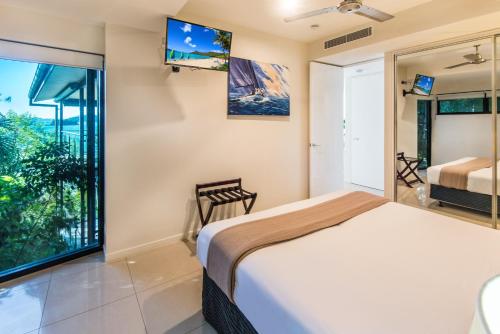 a bedroom with a bed and a large window at Edge Apartments on Hamilton Island by HIHA in Hamilton Island