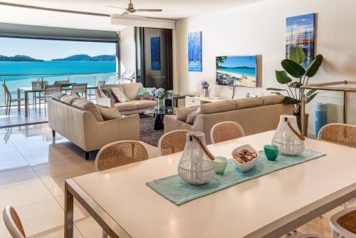 a living room with a table and chairs at Edge Apartments on Hamilton Island by HIHA in Hamilton Island