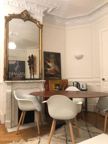 une salle à manger avec une table, des chaises et un miroir dans l'établissement Cosy 2 room 50m2 Parisian classic flat - Passy, 16th arrondissement, near Eiffel Tower, à Paris