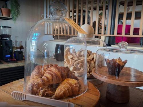 um frasco de vidro cheio de croissants e bolos numa mesa em Eleven em Plettenberg Bay