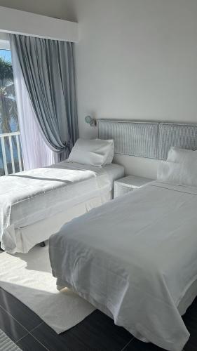 two beds in a room with a window at Vista Mare Samana Amazing Views!! in Santa Bárbara de Samaná