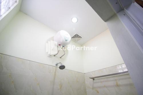 a bathroom with a white phone on the wall at Balmoral House Mitra RedDoorz near Ambarukmo Plaza Mall Yogyakarta in Yogyakarta