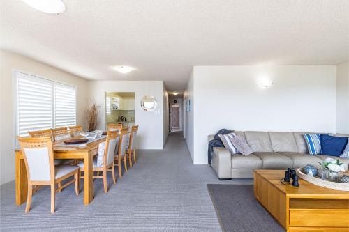 a living room with a table and a couch at Laman Lodge, 1,15 Laman Street - Stunning Views, air conditioned unit with water views and Wifi in Nelson Bay