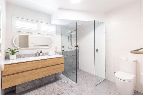 ein Bad mit einer Dusche, einem Waschbecken und einem WC in der Unterkunft Laman Lodge, 1,15 Laman Street - Stunning Views, air conditioned unit with water views and Wifi in Nelson Bay