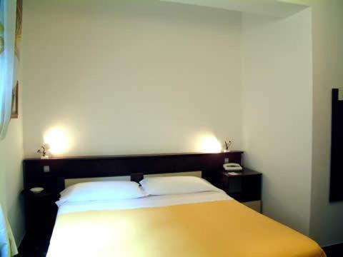 1 dormitorio con 1 cama amarilla y 2 almohadas en Bridge Hotel, en Bagni di Lucca