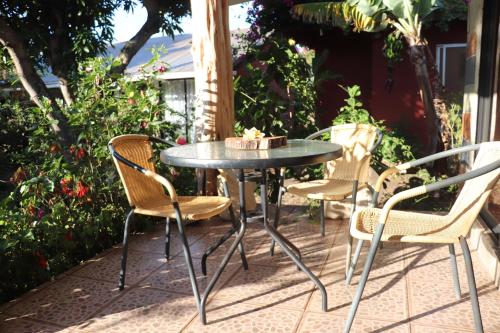 une table et des chaises assises sur une terrasse dans l'établissement Hostal Avareipua, à Hanga Roa