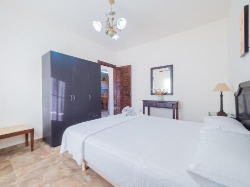 アラウリン・デ・ラ・トレにあるCubo's Finca La Higueraのベッドルーム(白いベッド1台、黒いキャビネット付)