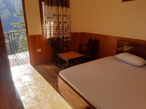 a bedroom with a bed and a balcony at Aagaman Woods Homestay in Shimla