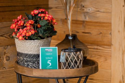a table with a vase of flowers and a candle at Ferienparadies Taxen in Sankt Veit im Pongau