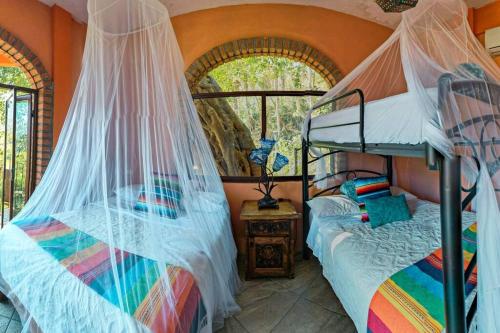 a bedroom with two bunk beds with mosquito nets at Casa Flourish, Yelapa in Yelapa