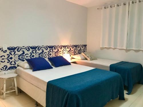 2 camas en una habitación de color azul y blanco en 3 QUARTOS,10 min a pé Praia Grande, GARAGEM 3 carros, Churrasqueira, Wi-Fi e Cozinha Completa, en Arraial do Cabo