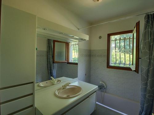uma casa de banho com 2 lavatórios e um espelho em Maison Casaglione-Tiuccia, 4 pièces, 6 personnes - FR-1-61-510 em Casaglione