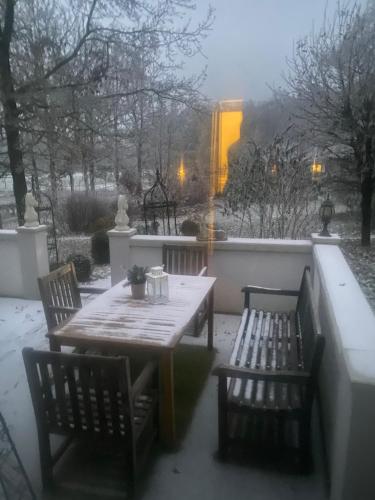 a table and two chairs with snow on a patio at Farm stay Hof auf der Wurp in Harrierwurp