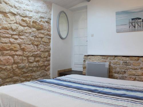 une chambre avec un lit et un mur en pierre dans l'établissement Maison 4 pers avec Terrasse et Jardin, à 2 pas du Port et de l'Océan – La Cotinière, Oléron - FR-1-246A-95, à Saint-Pierre-dʼOléron