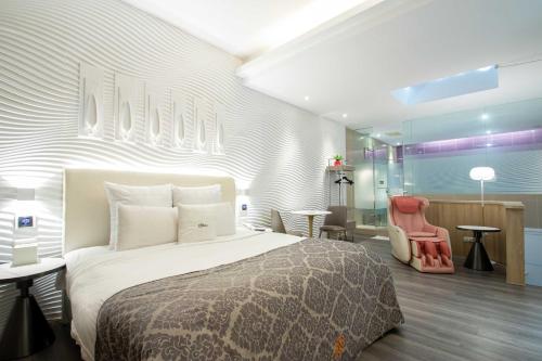 a bedroom with a bed and a desk and a chair at 168 Motel-Taoyuan in Taoyuan