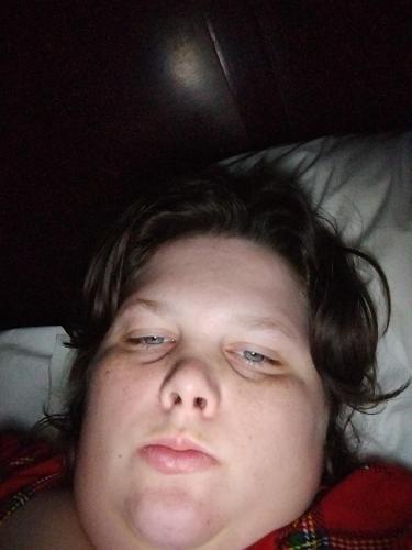 un joven acostado en una cama con la cabeza en una almohada en Na, en Greenville