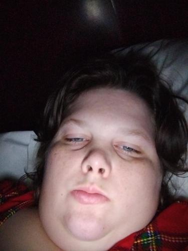 Un joven acostado en una cama con los ojos cerrados en Na, en Greenville