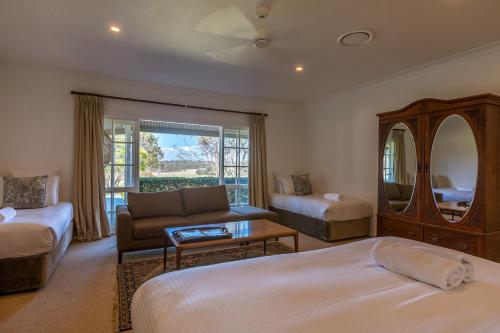 a bedroom with a bed and a couch and a table at Corunna Station Country House in Belford