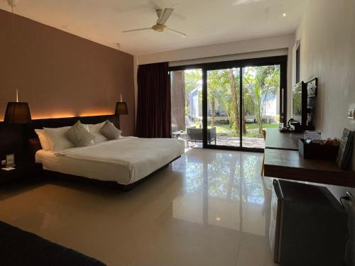 a bedroom with a bed and a sliding glass door at Cede Boutique Beach Resort in Ko Phayam