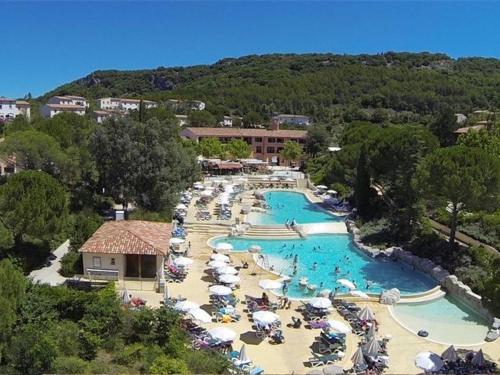 - une vue aérienne sur la piscine du complexe avec des parasols dans l'établissement Maison Duplex 5p avec Terrasse, WIFI et Parking, Grospierres - FR-1-382-86, à Grospierres