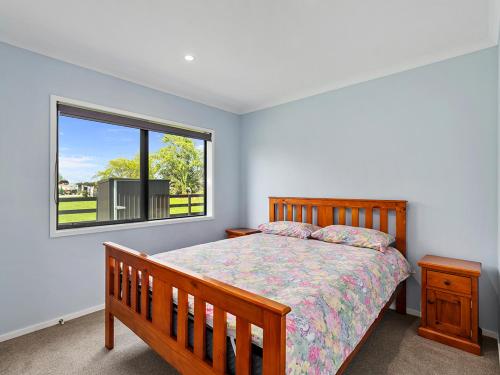 a bedroom with a bed and a window at Mangawhai Monarch - Mangawhai Heads Holiday Home in Mangawhai