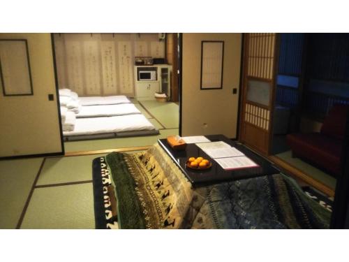 高山市にあるTomareru sento taka no yu - Vacation STAY 00556vのベッド2台、テーブルにオレンジのトレイが備わる客室です。