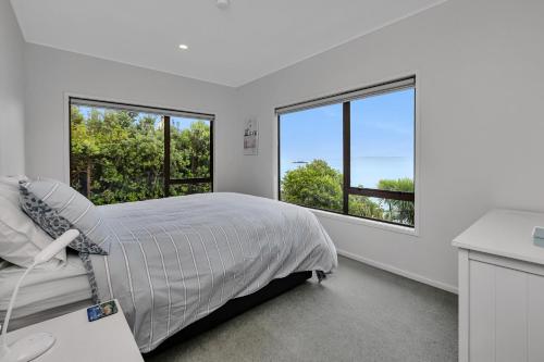 een slaapkamer met een bed en 2 ramen bij Coopers Sands - Coopers Beach Holiday Home in Coopers Beach