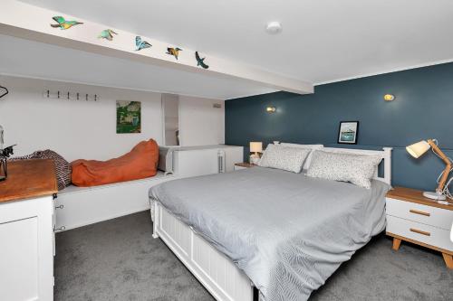 a bedroom with a white bed and blue walls at Coopers Sands - Coopers Beach Holiday Home in Coopers Beach