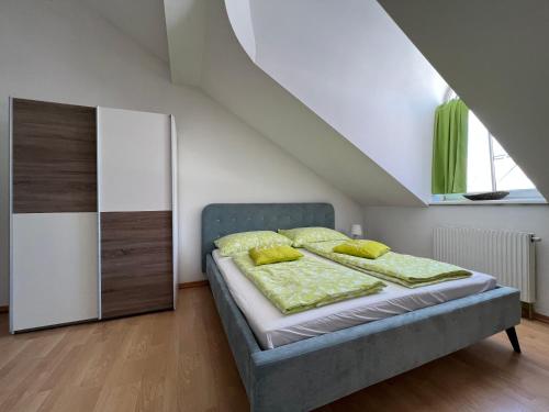 ウィーンにあるヴィエナ エクセレント アパートメンツのベッドルーム1室(緑のシーツと黄色の枕が備わるベッド1台付)