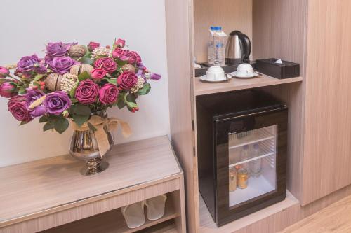 a bouquet of purple roses in a vase next to a fireplace at New York Hotel in Phnom Penh