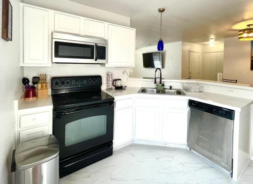 uma cozinha com armários brancos e uma máquina de lavar louça preta em Private rooms near I-30 mesquite em Dallas