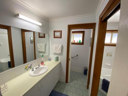 baño con lavabo y espejo grande en Pull Up Stumps, en Rutherglen