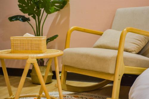 a room with a chair and a table with a plant at Ashare Hotel in Jiaoxi