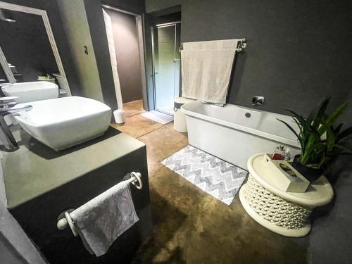 a bathroom with a tub and a toilet and a sink at Ukuthula @ the Kruger in Marloth Park