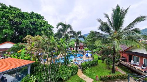 an aerial view of a resort with a pool and palm trees at Andaman Seaside Resort - SHA Extra Plus in Bang Tao Beach