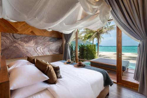 a bedroom with a bed with a view of the beach at Irene Pool Villa Resort, Koh Lipe in Ko Lipe