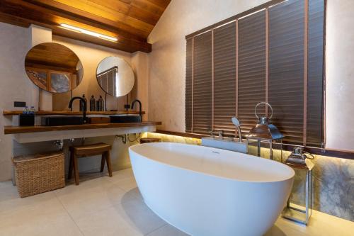 a bathroom with a large tub and a sink at Irene Pool Villa Resort, Koh Lipe in Ko Lipe