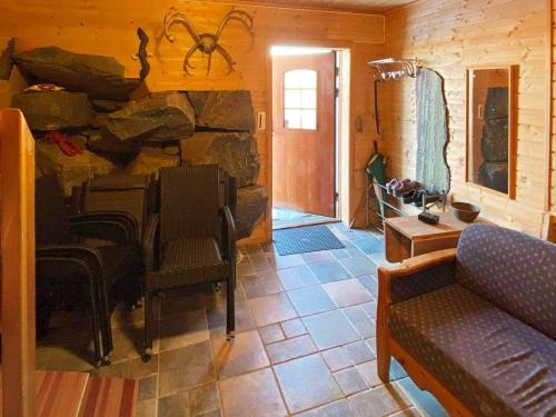 a living room with a couch and a stone wall at Holiday home byrknesøy in Ånneland