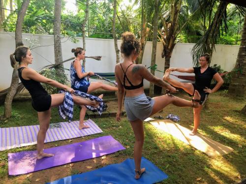 a group of women doing yoga in a yard at Hostel Singha Lounge in Unawatuna