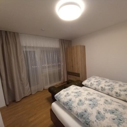 a bedroom with two beds and a large window at Pension Alpina in Roppen