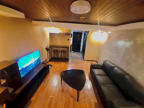 a living room with a couch and a flat screen tv at IV’s Condo w/ Netflix and Wi-Fi in Cainta