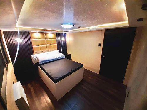 Habitación pequeña con cama en el medio en IV’s Condo w/ Netflix and Wi-Fi en Cainta