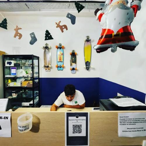 a man sitting at a counter in a store at Bluewaters Pods 38 Hongkong St in Singapore