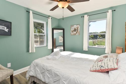 a bedroom with blue walls and a bed with a ceiling fan at Off The Beaten Path Rancher! Beautifully Made in Rosedale