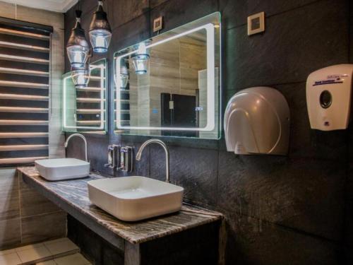 a bathroom with two sinks and a mirror at BON Hotel Nest Ibadan in Ibadan