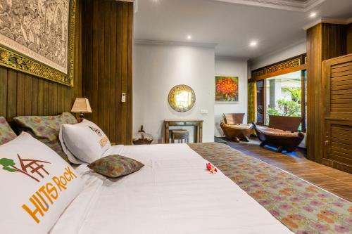 1 dormitorio con 1 cama blanca grande y chimenea en Huts Rock Ubud en Ubud