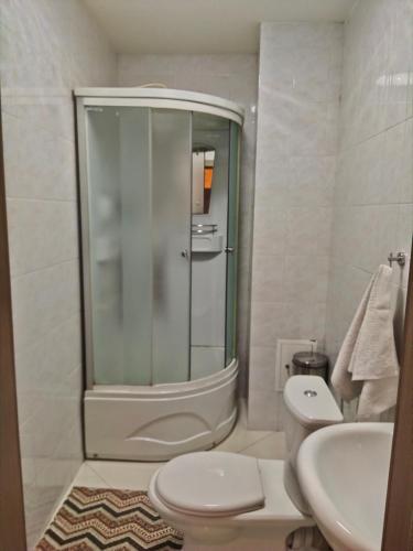 y baño con ducha, aseo y lavamanos. en Гостиница ,,Меркурий и К,, en Astaná