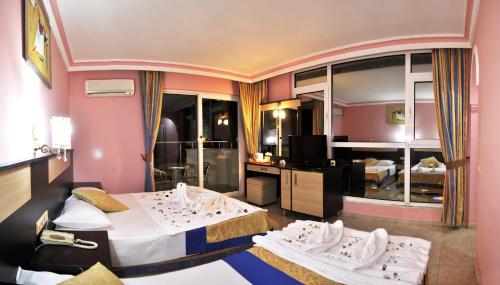 a hotel room with two beds and a television at First Class Hotel - All Inclusive in Kargicak