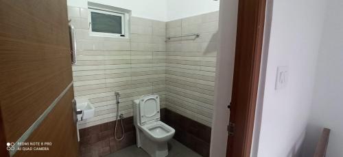 a small bathroom with a toilet and a window at 3R Residency Munnar in Munnar