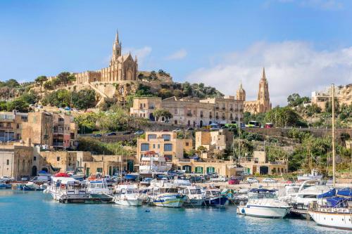 a group of boats in a harbor with a city at Villeleynah Amazing Gozitan Villa Pool - Happy Rentals in Munxar